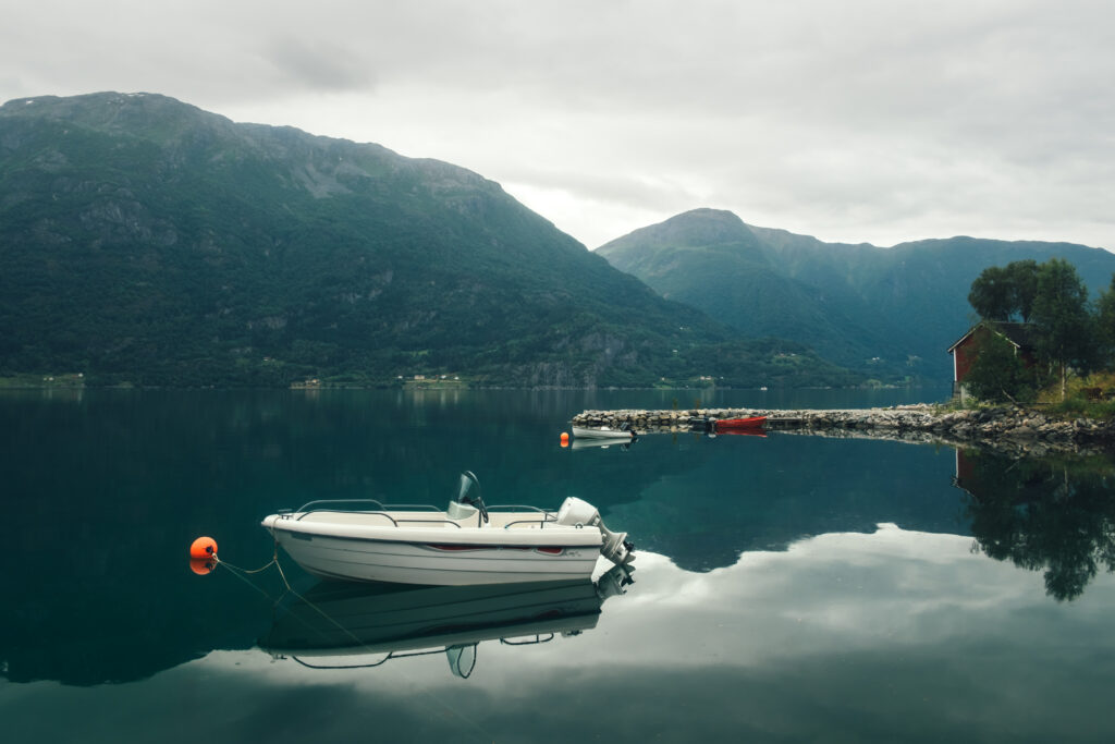 Morgendlicher Blick auf einen See mit einem Boot im Vordergrund
