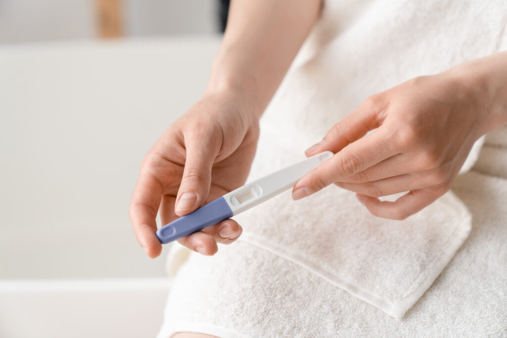 Frau hält Schwangerschaftstest in der Hand