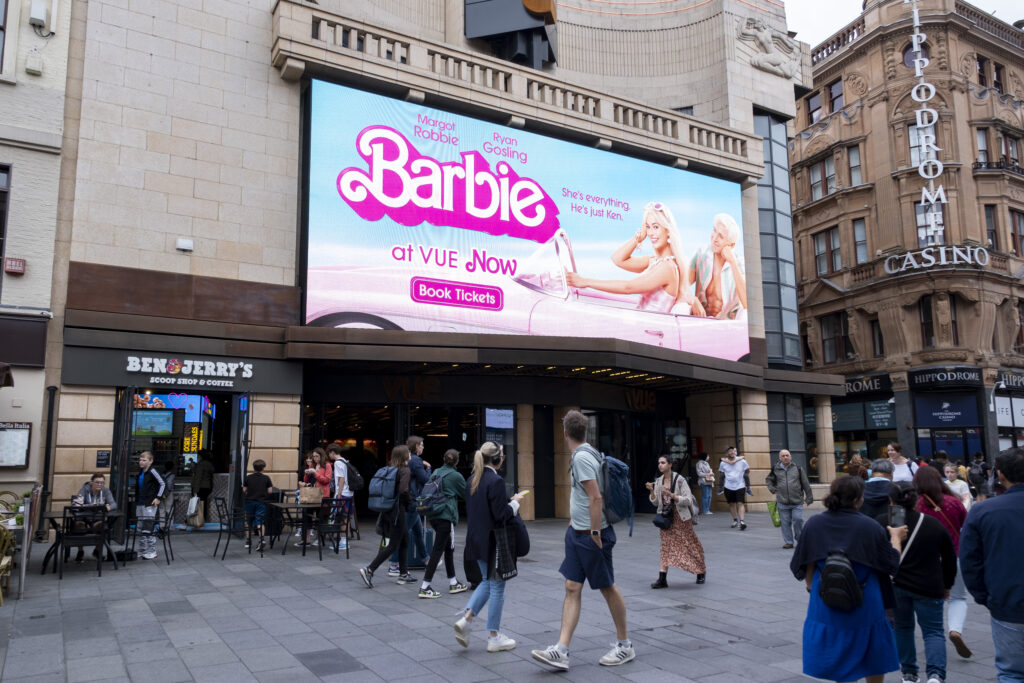 Werbetafel ist an Häuserwand angebracht und präsentiert Barbie-Film.
