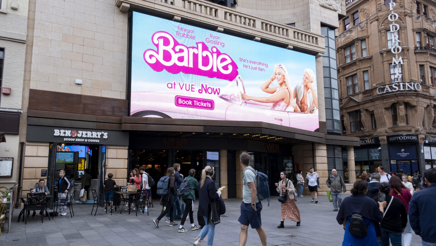 Werbetafel ist an Häuserwand angebracht und präsentiert Barbie-Film.