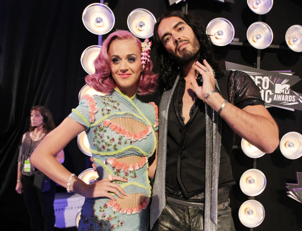 Katy Perry in farbenfrohem Outfit und Russell Brand neben ihr
