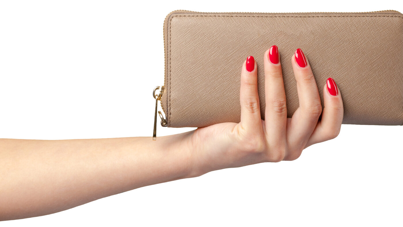 Frauenhand mit roten Nägeln hält eine Geldtasche in braun