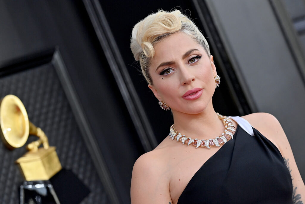 Lady Gaga mit Halskette, blonder Hochsteckfrisur und schwarzem Kleid ohne Ärmel in Nahaufnahme
