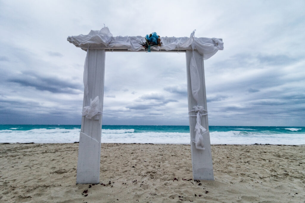 Hochzeitsbogen in weiß am Strand bei schlechtem Wetter