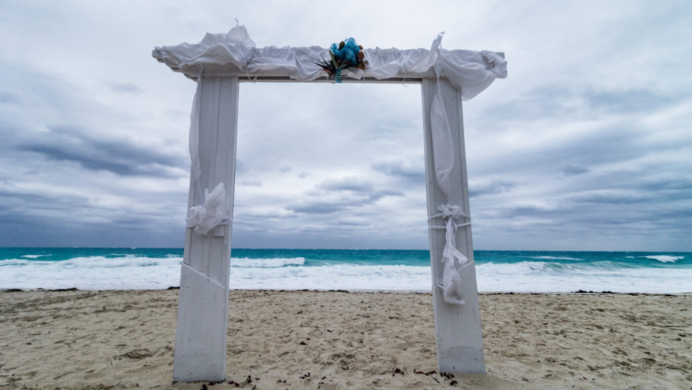 Hochzeitsbogen in weiß am Strand bei schlechtem Wetter