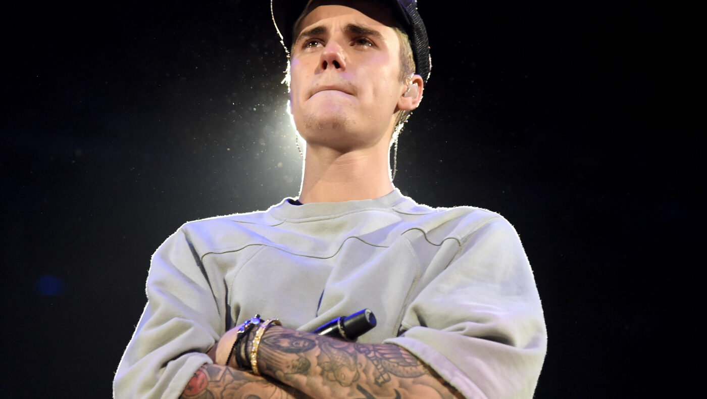 Justin Bieber steht auf der Bühne und verschränkt die Arme