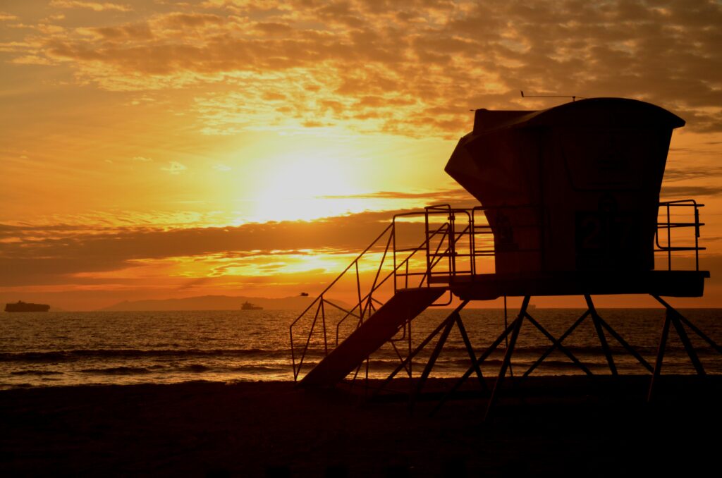 Sonnenuntergang mit Rettungsturm am Strand