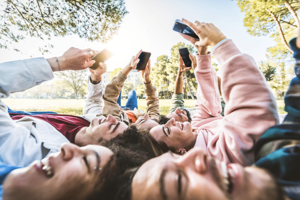 Personen schauen auf hochgehaltenes Handy