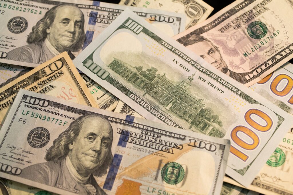 Ein Stapel US-Dollar-Scheine neben einer Wahlurne symbolisiert die Elon-Musk-Spende an republikanische Wahlkampfgruppen – Foto: benscripps / Pixabay