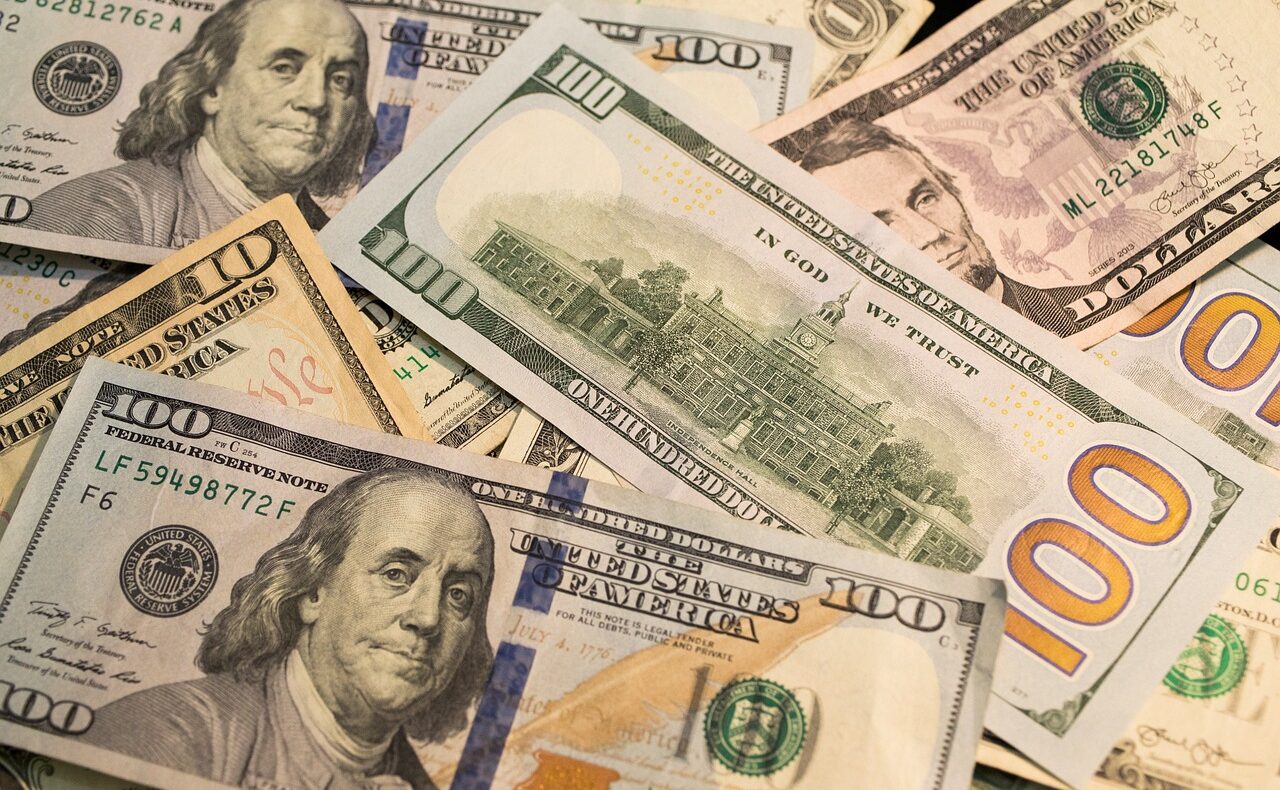 Ein Stapel US-Dollar-Scheine neben einer Wahlurne symbolisiert die Elon-Musk-Spende an republikanische Wahlkampfgruppen – Foto: benscripps / Pixabay