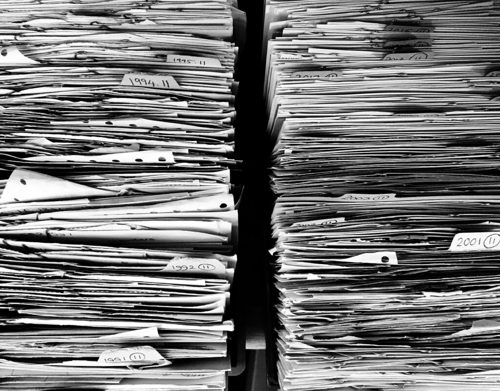 Ein Stapel Insolvenzakten auf einem Schreibtisch symbolisiert die steigenden Firmeninsolvenzen in Österreich – Foto: myrfa / Pixabay