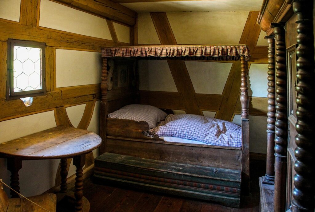 Antikes Ehebett mit geschnitzter Kopfseite steht in einem Auktionshaus, wie es bei der Heino-Ehebett-Auktion versteigert wird – Foto: garten-gg / Pixabay
