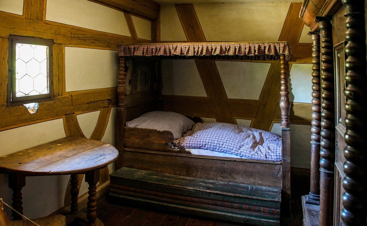Antikes Ehebett mit geschnitzter Kopfseite steht in einem Auktionshaus, wie es bei der Heino-Ehebett-Auktion versteigert wird – Foto: garten-gg / Pixabay